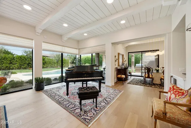 a living room with furniture a rug and a floor to ceiling window