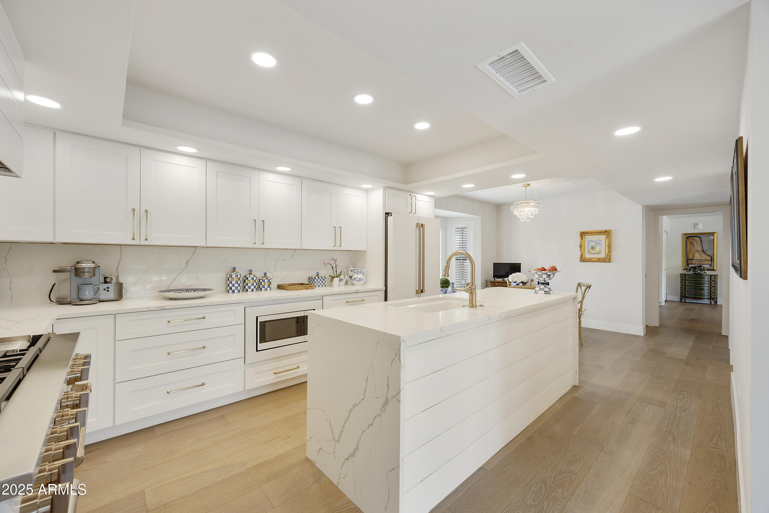 4436 East Camelback Road, Unit 37 Phoenix, AZ 85018 - Photo 22 of 55 a large white kitchen with kitchen island a sink a stove and a refrigerator with wooden floor