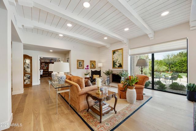 a view of a patio with table and chairs under an umbrella with palm trees