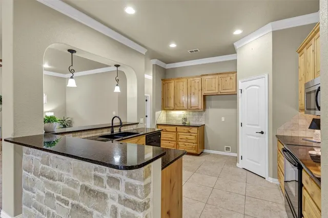 a kitchen with stainless steel appliances granite countertop a sink and a refrigerator