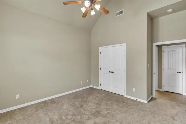 a view of an empty room with a chandelier fan