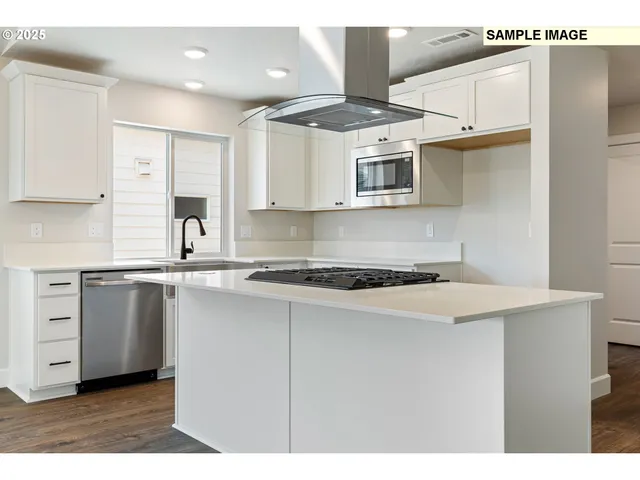 a kitchen with kitchen island granite countertop a sink cabinets and stainless steel appliances