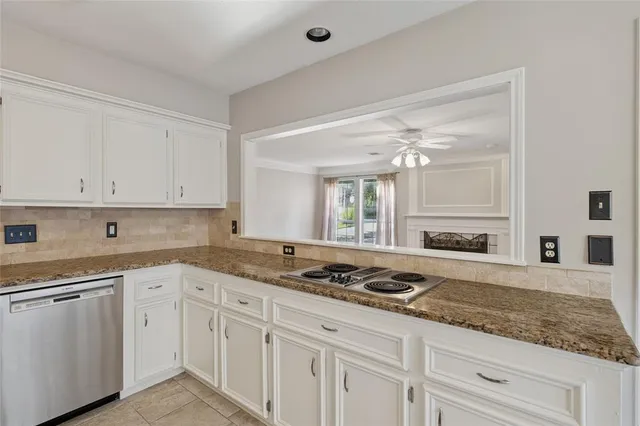 a kitchen with granite countertop white cabinets and white appliances