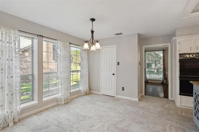 a view of an empty room with window and cabinet