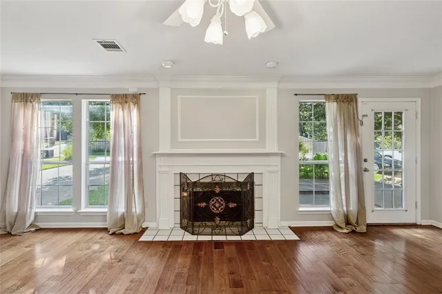 a living room with fireplace and wooden floor