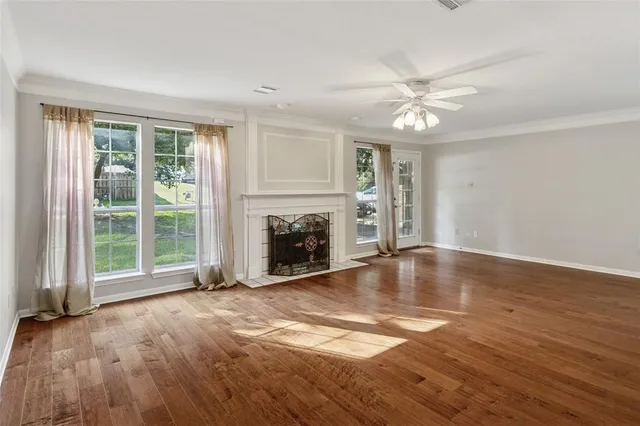 a view of empty room with wooden floor and fireplace