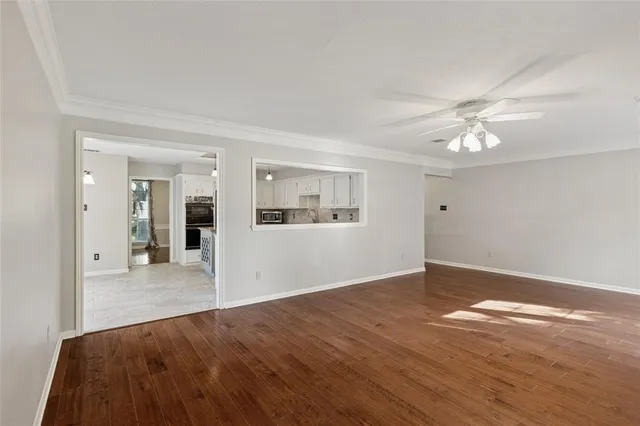 a view of a livingroom with wooden floor and a ceiling fan
