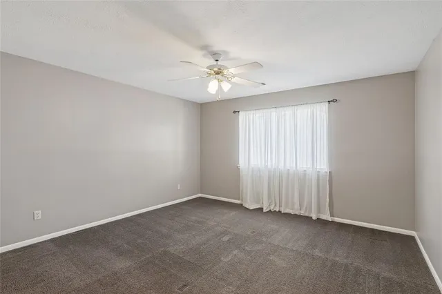 a view of an empty room with a ceiling fan