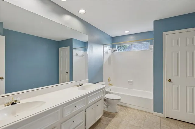 a bathroom with a granite countertop sink a toilet and shower