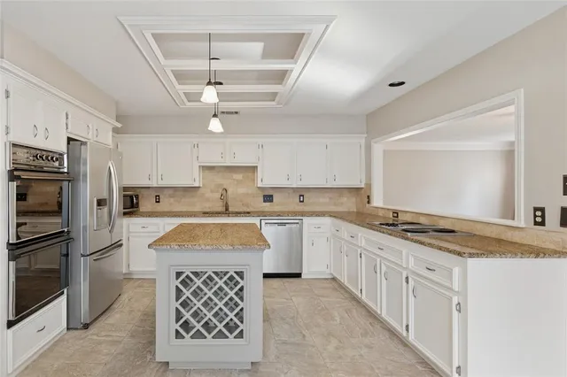 a kitchen with granite countertop a sink stainless steel appliances and cabinets