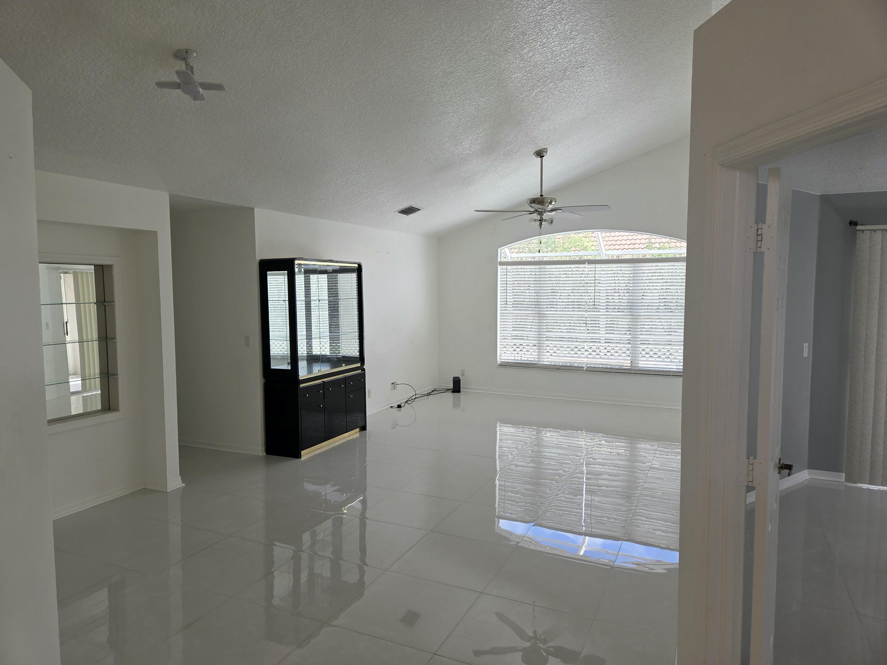 3021 Casa Rio Court Riviera Beach, FL 33418 - Photo 4 of 16 wooden floor in an empty room with a window