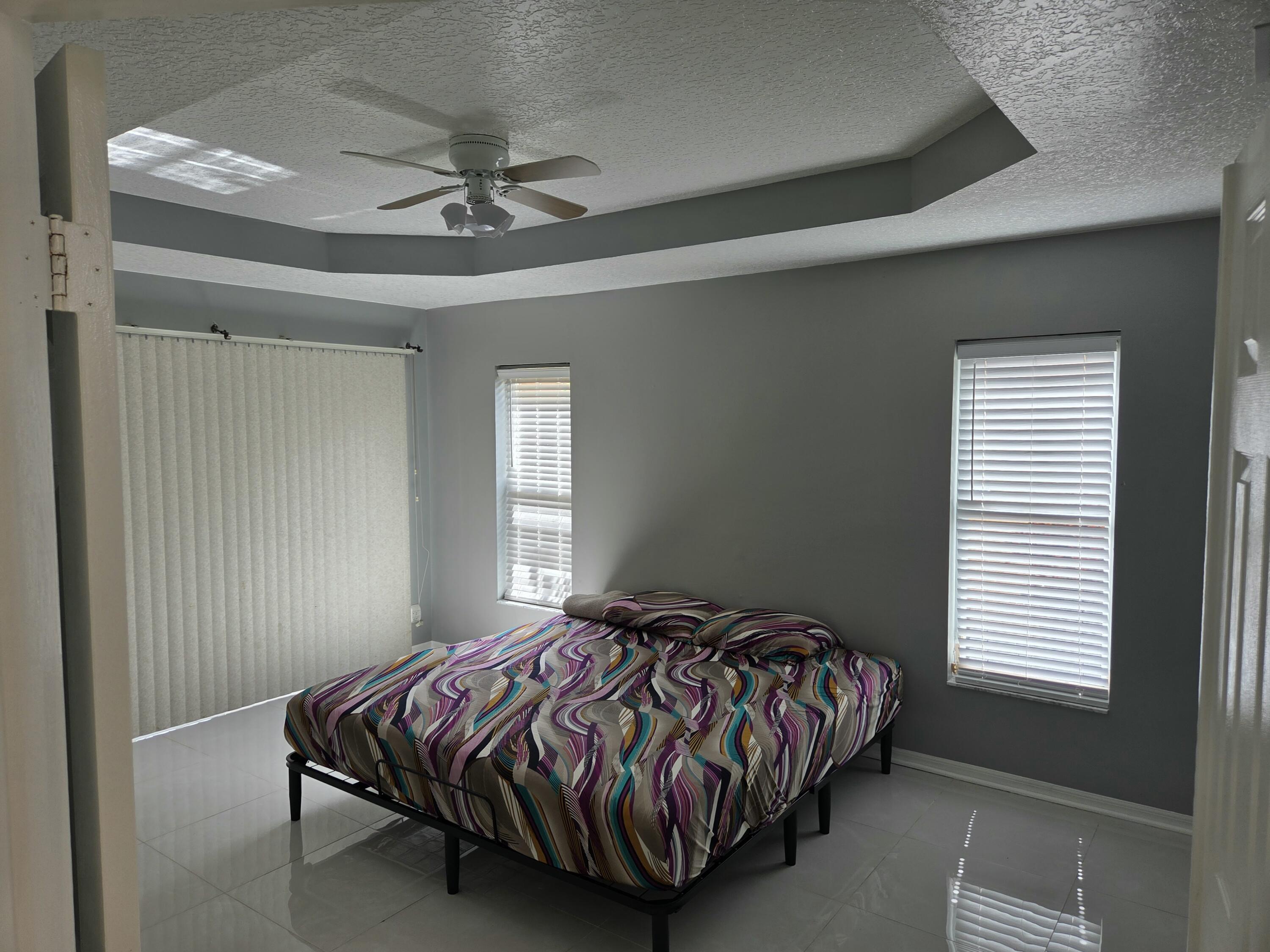 3021 Casa Rio Court Riviera Beach, FL 33418 - Photo 5 of 16 a bedroom with a bed and window