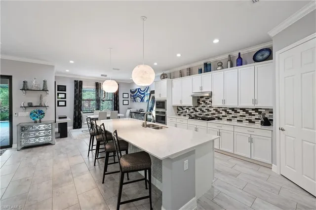 a kitchen with stainless steel appliances a table chairs and a refrigerator