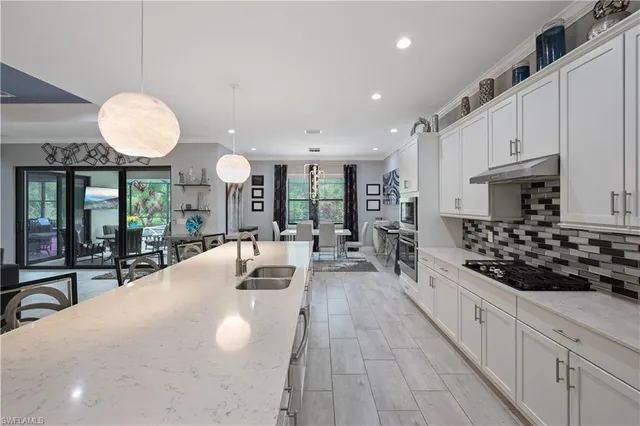 a large kitchen with stainless steel appliances a large counter space a sink and cabinets
