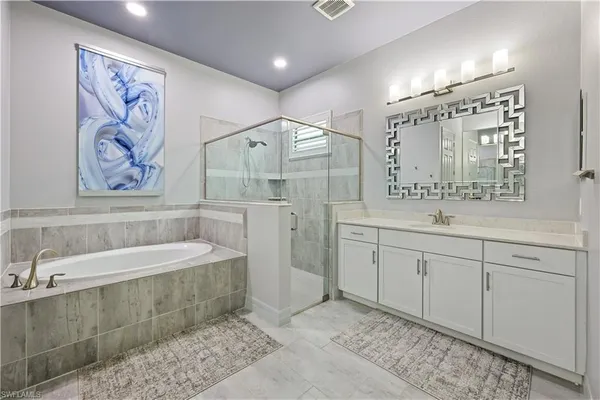 a spacious bathroom with a double vanity sink mirror and a bathtub