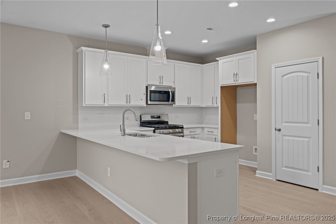 274 Rough Ridge Trail Aberdeen, NC 28315 - Photo 14 of 47 a kitchen with kitchen island a sink stainless steel appliances and cabinets