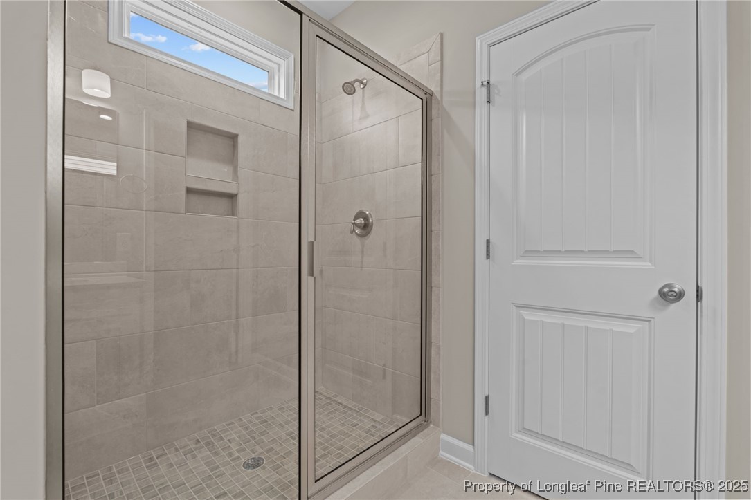 274 Rough Ridge Trail Aberdeen, NC 28315 - Photo 24 of 47 a bathroom with a glass shower door