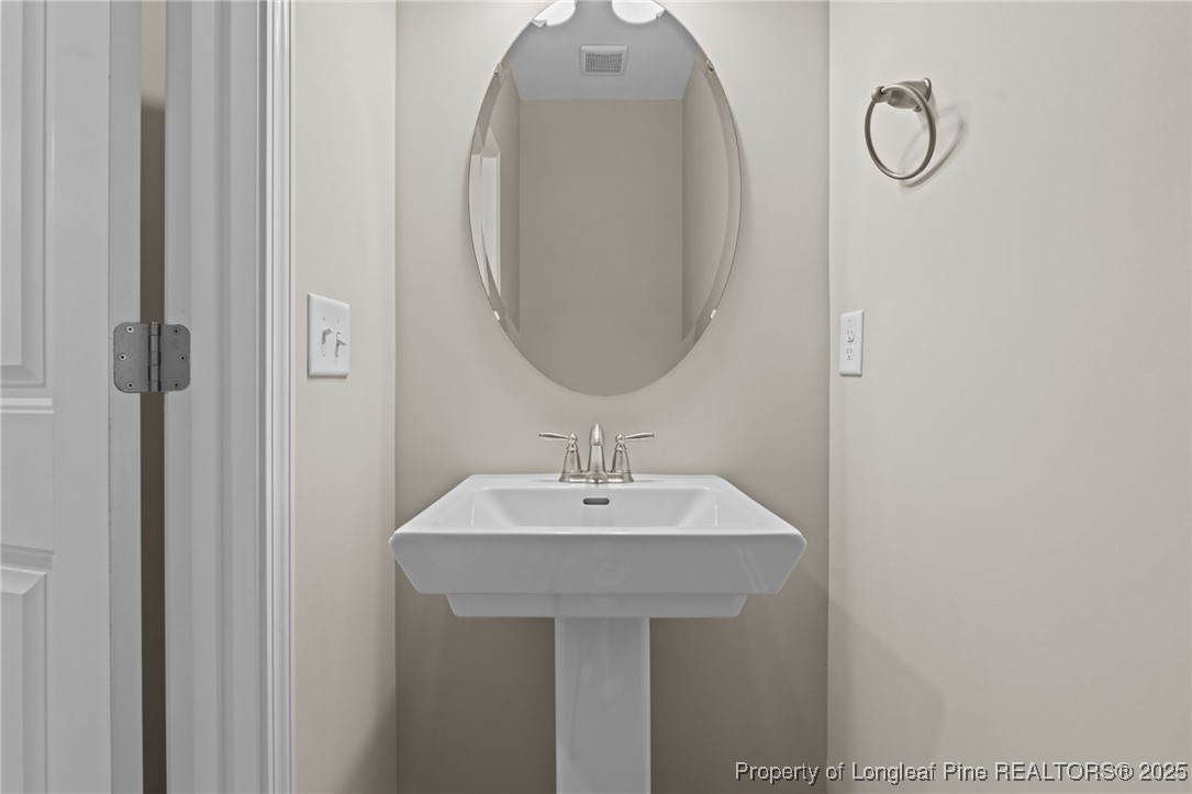 274 Rough Ridge Trail Aberdeen, NC 28315 - Photo 9 of 47 a bathroom with a sink and a mirror