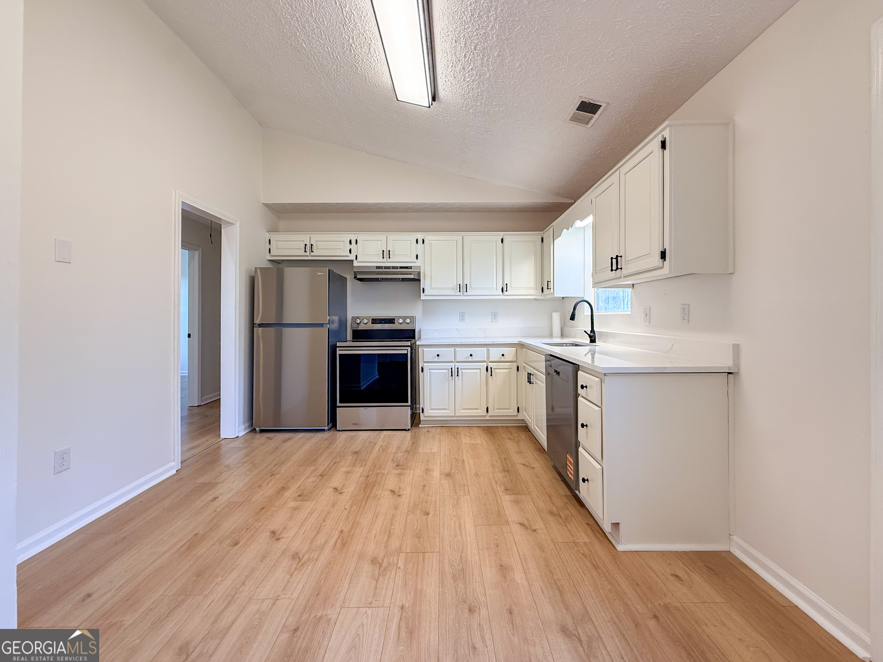 1492 Highway 198 Carnesville, GA 30521 - Photo 7 of 25 a kitchen with cabinets and stainless steel appliances