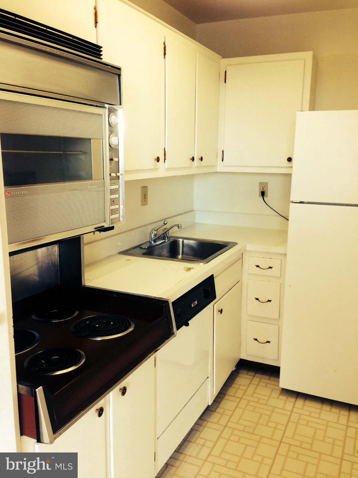 9701 Fields Road, Unit 1106 Gaithersburg, MD 20878 - Photo 2 of 6 a kitchen with a sink and a stove