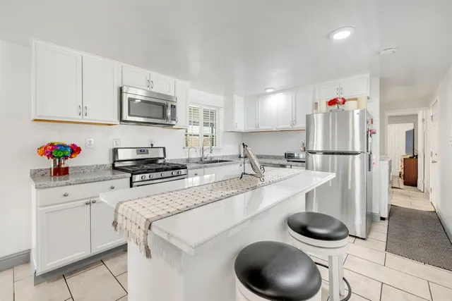 a kitchen with stainless steel appliances granite countertop a sink and a refrigerator
