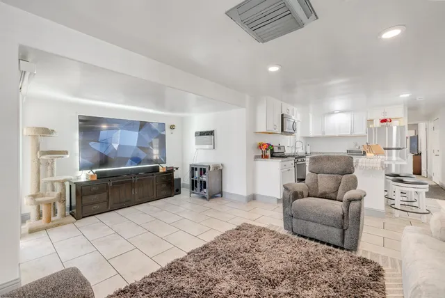 a living room with furniture and kitchen view