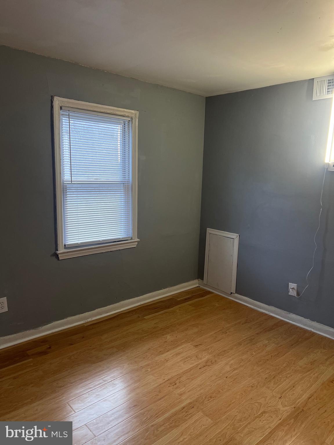 5047 Benning Road Southeast, Unit B Washington, DC 20019 - Photo 13 of 19 a view of an empty room with wooden floor and a window