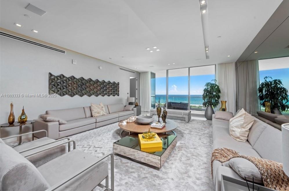 a living room with furniture kitchen view and a large window