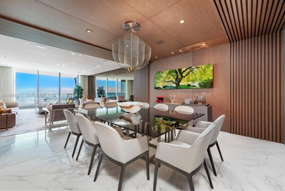 9349 Collins Avenue, Unit 304 Surfside, FL 33154 - Photo 13 of 40 a dining room with furniture a floor to ceiling window and plants