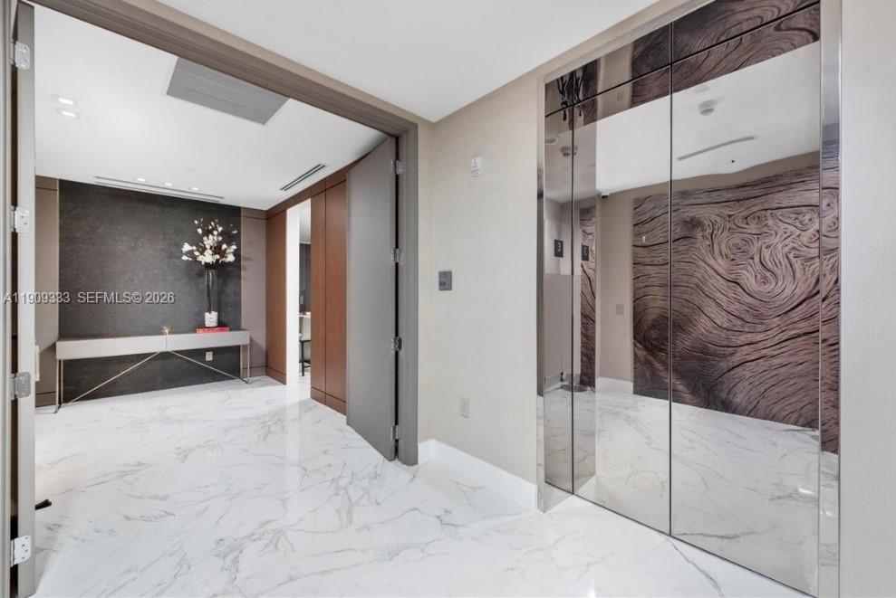 9349 Collins Avenue, Unit 304 Surfside, FL 33154 - Photo 16 of 40 a view of a hallway with wooden cabinets