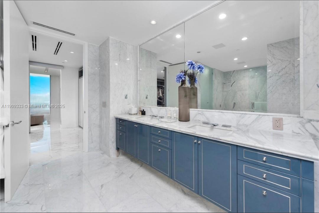 9349 Collins Avenue, Unit 304 Surfside, FL 33154 - Photo 17 of 40 a bathroom with a double vanity sink and a mirror