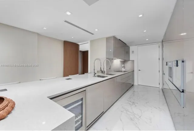 a large white kitchen with a stove a sink and a refrigerator