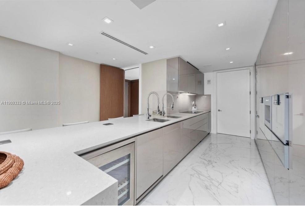 9349 Collins Avenue, Unit 304 Surfside, FL 33154 - Photo 19 of 40 a large white kitchen with a stove a sink and a refrigerator