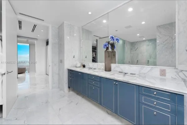 a bathroom with a granite countertop sink a large mirror and shower