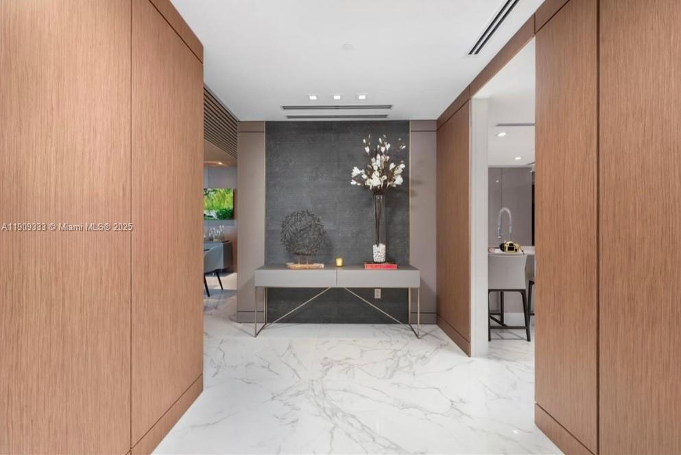 9349 Collins Avenue, Unit 304 Surfside, FL 33154 - Photo 22 of 40 a view of a hallway with a chandelier