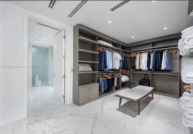 a view of a hallway with seating area and mirrors