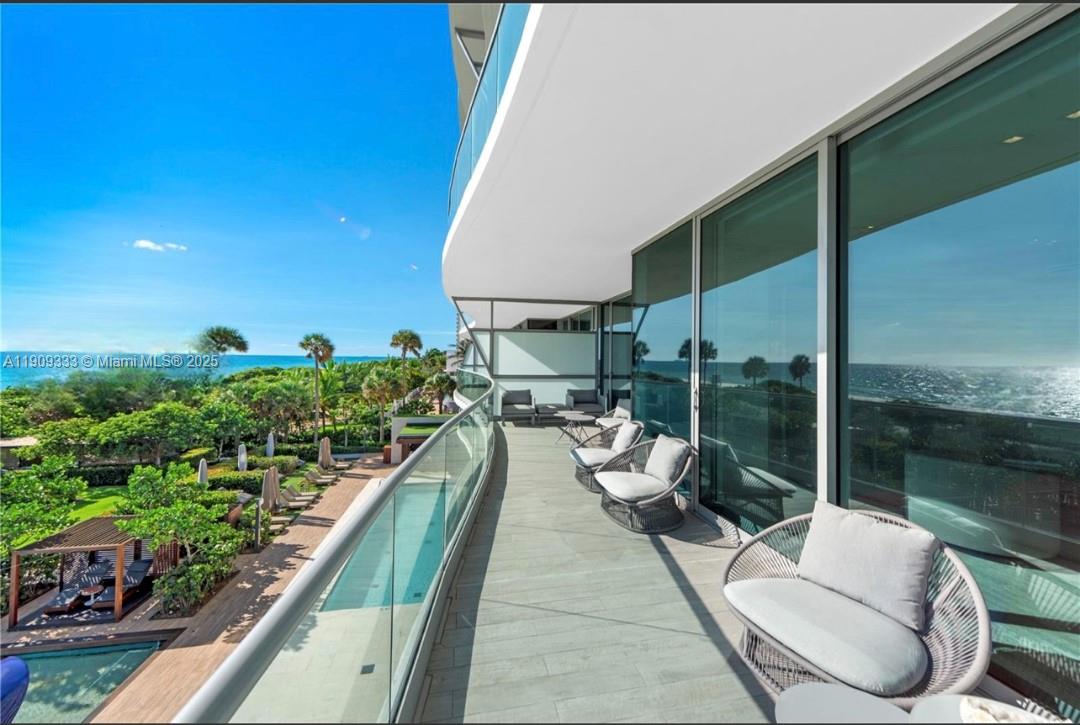 9349 Collins Avenue, Unit 304 Surfside, FL 33154 - Photo 30 of 40 a view of a balcony with chairs and potted plants
