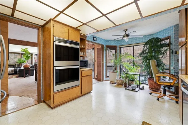 a living room with furniture a floor to ceiling window and potted plants
