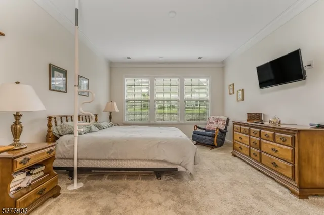 a bedroom with a bed and a flat tv screen on the dresser