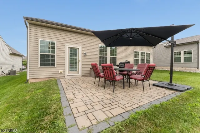 a view of a backyard with table and chairs under an umbrella