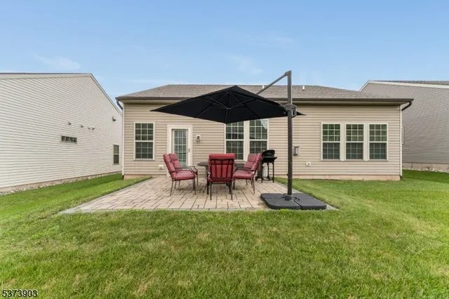 a view of a backyard with table and chairs under an umbrella