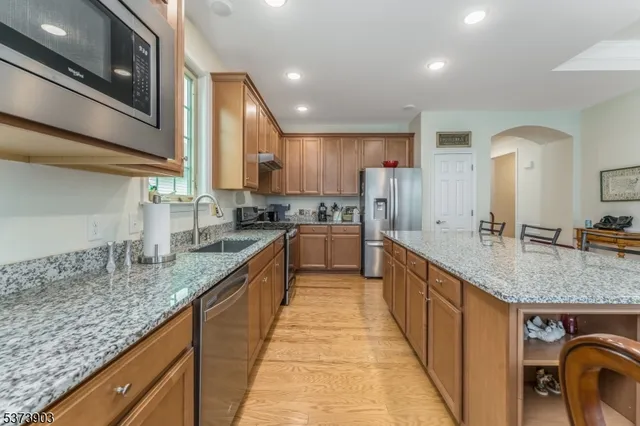 a large kitchen with stainless steel appliances granite countertop a sink and cabinets