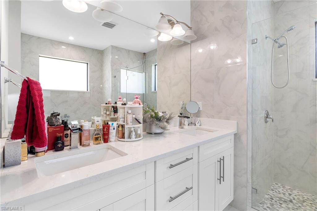 2406 37th Avenue Northeast Naples, FL 34120 - Photo 11 of 29 Full bathroom with tile walls, a marble finish shower, and double vanity