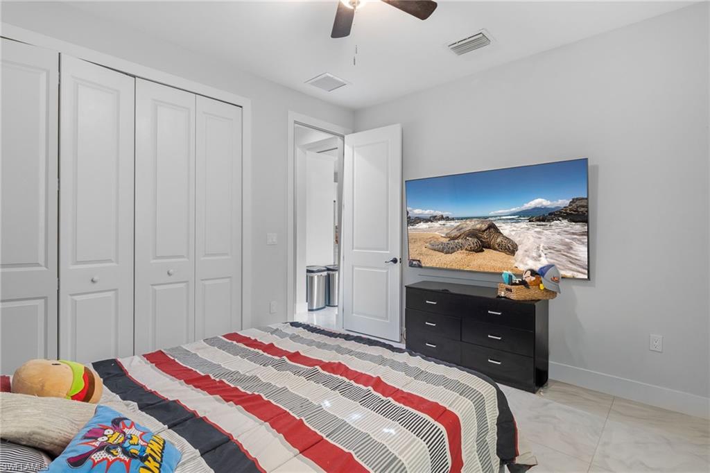 2406 37th Avenue Northeast Naples, FL 34120 - Photo 13 of 29 Bedroom with a closet and a ceiling fan