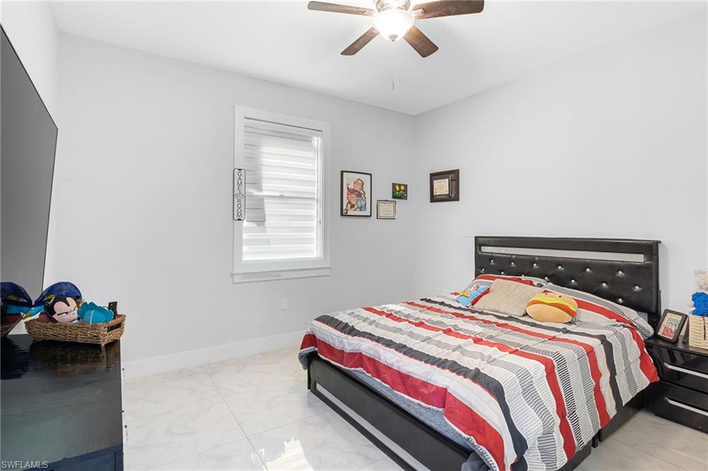 2406 37th Avenue Northeast Naples, FL 34120 - Photo 14 of 29 Bedroom with ceiling fan and light marble finish floors