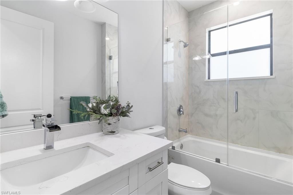 2406 37th Avenue Northeast Naples, FL 34120 - Photo 15 of 29 Full bath featuring vanity and shower / bath combination with glass door