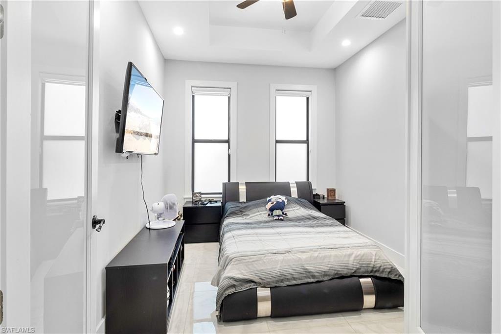 2406 37th Avenue Northeast Naples, FL 34120 - Photo 18 of 29 Bedroom featuring recessed lighting, a ceiling fan, and a tray ceiling