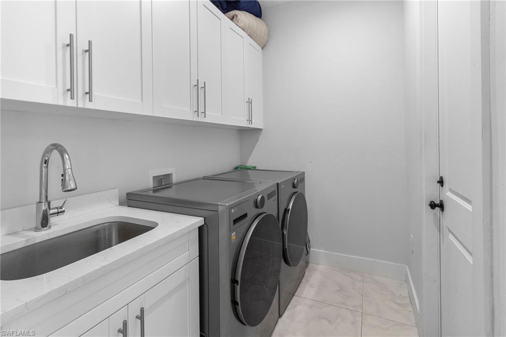 2406 37th Avenue Northeast Naples, FL 34120 - Photo 19 of 29 Laundry area featuring independent washer and dryer and cabinet space