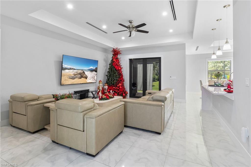 2406 37th Avenue Northeast Naples, FL 34120 - Photo 2 of 29 Living area featuring a raised ceiling, recessed lighting, french doors, a ceiling fan, and light marble finish flooring