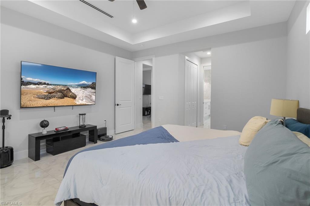 2406 37th Avenue Northeast Naples, FL 34120 - Photo 9 of 29 Bedroom featuring a raised ceiling, a ceiling fan, ensuite bath, a closet, and recessed lighting